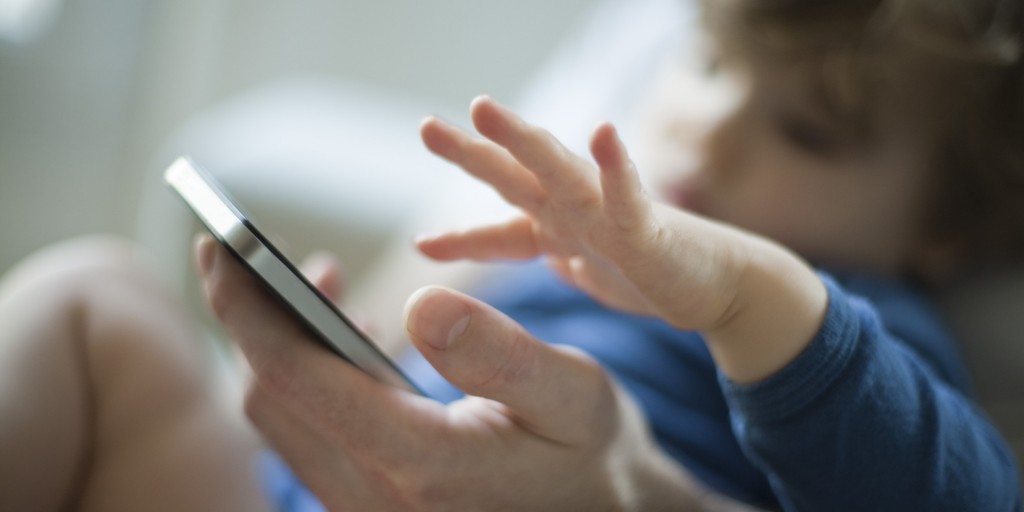 Toddler touching father's cell phone